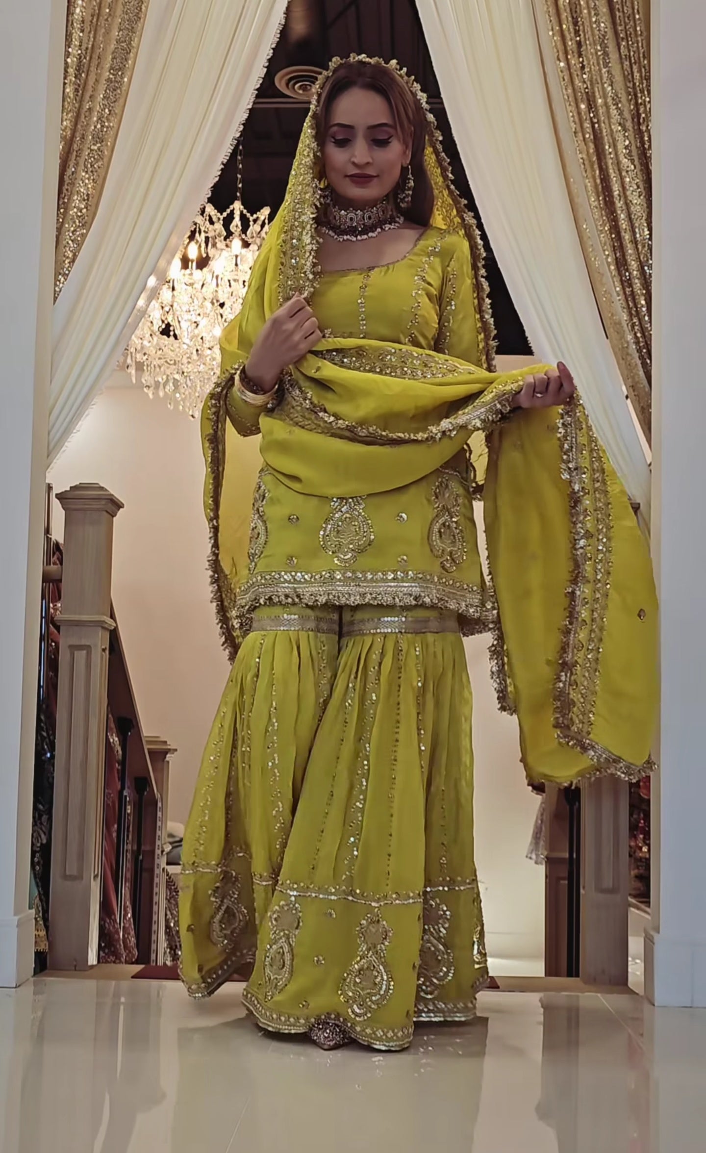 Perfect for festive occasions, this elegant yellow sharara suit features heavy golden embroidery.