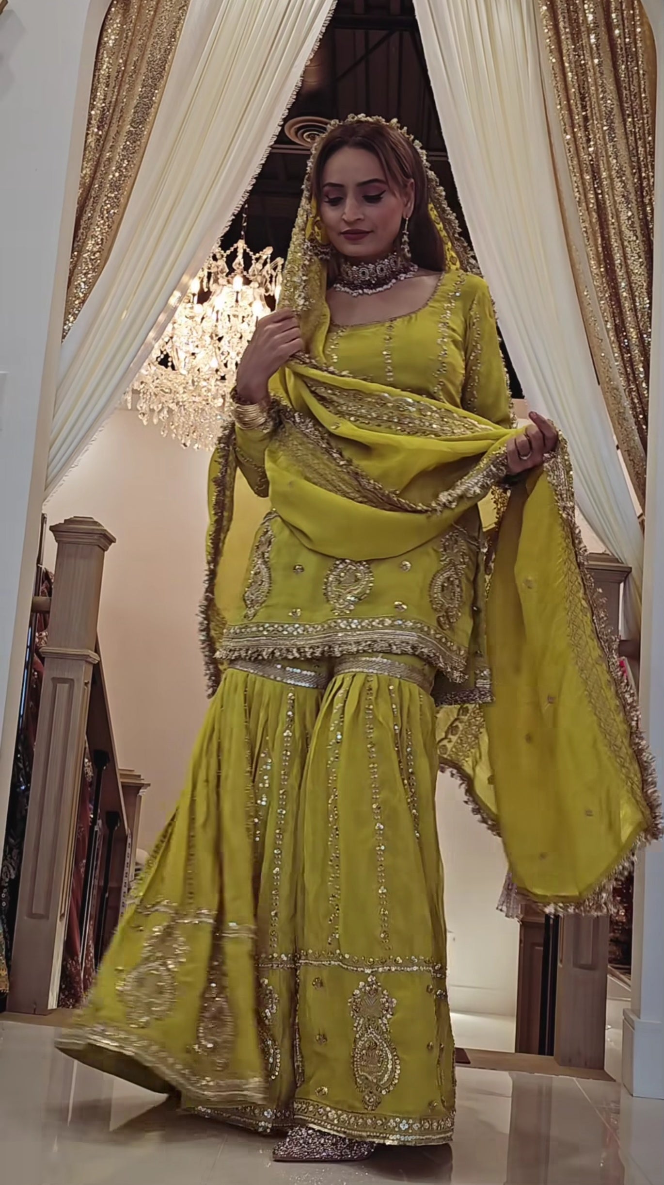 Perfect for festive occasions, this elegant yellow sharara suit features heavy golden embroidery.