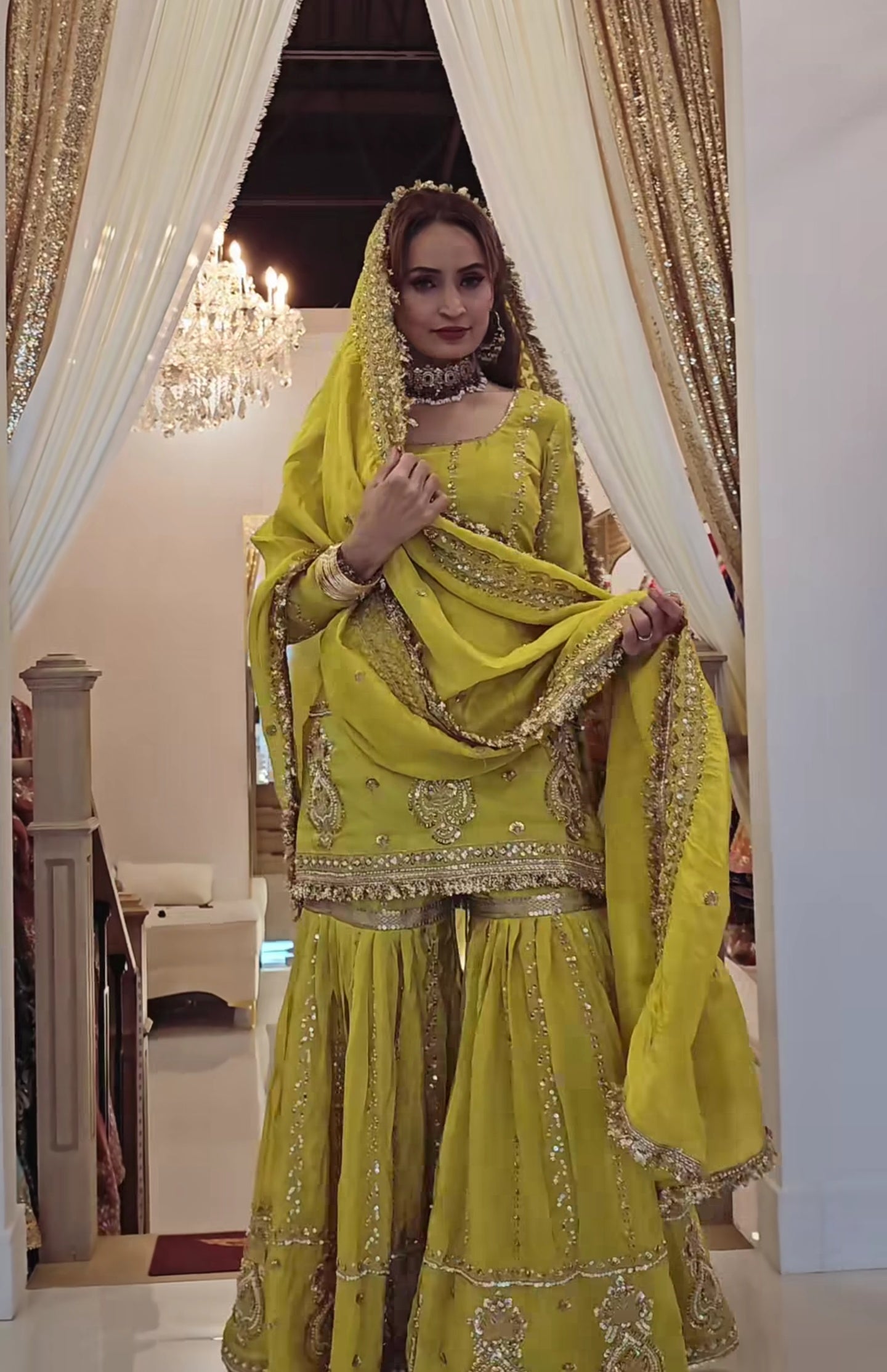 Perfect for festive occasions, this elegant yellow sharara suit features heavy golden embroidery.
