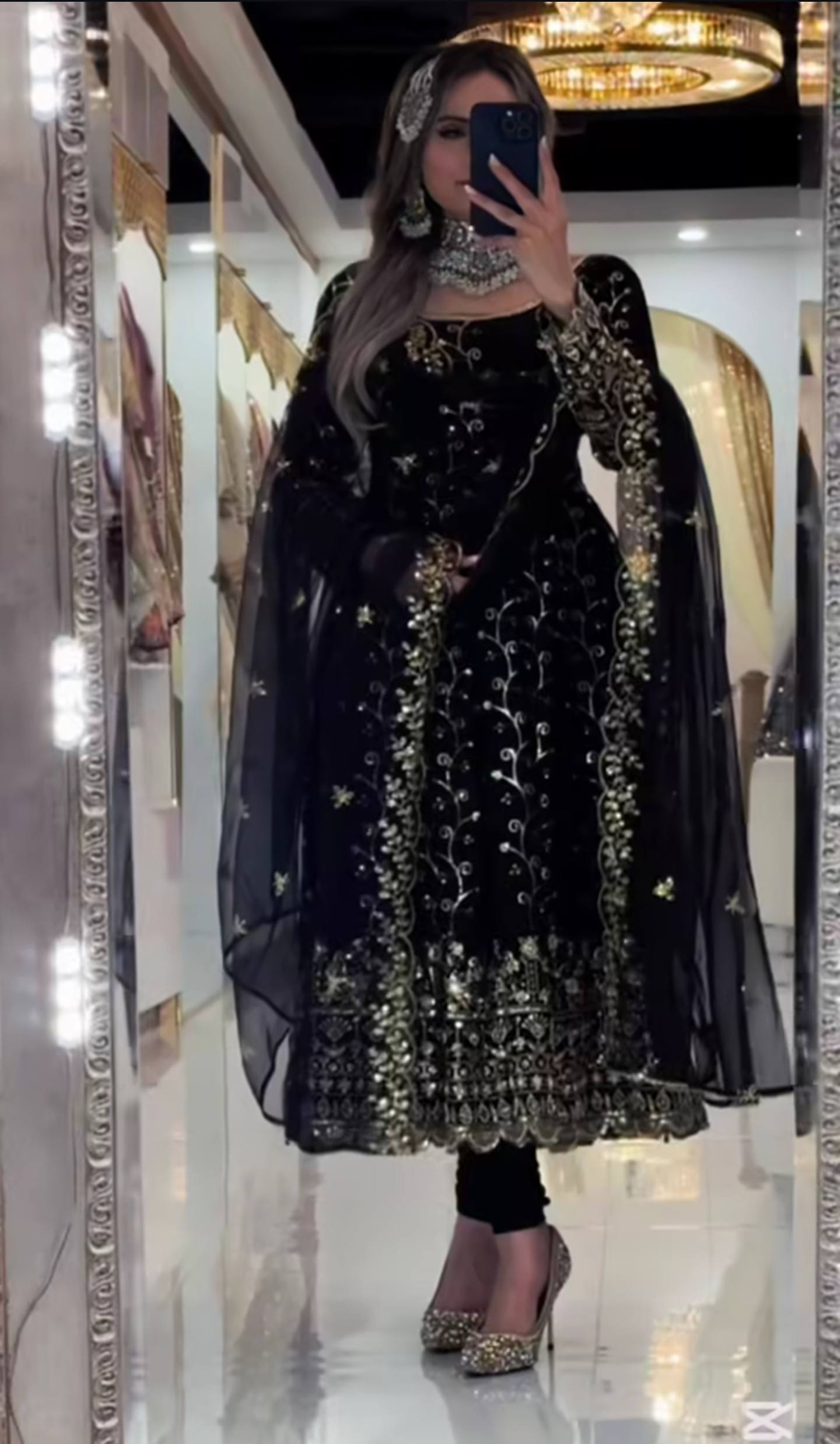 Person wearing a black and gold embroidered outfit in a mirror selfie.