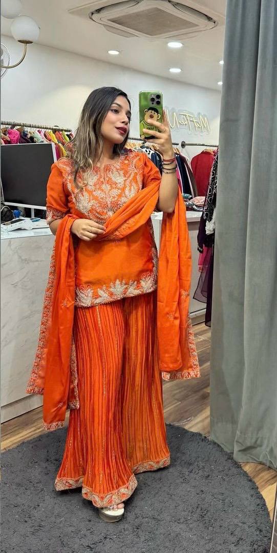 Stylish orange sharara suit paired with a sheer, embroidered dupatta